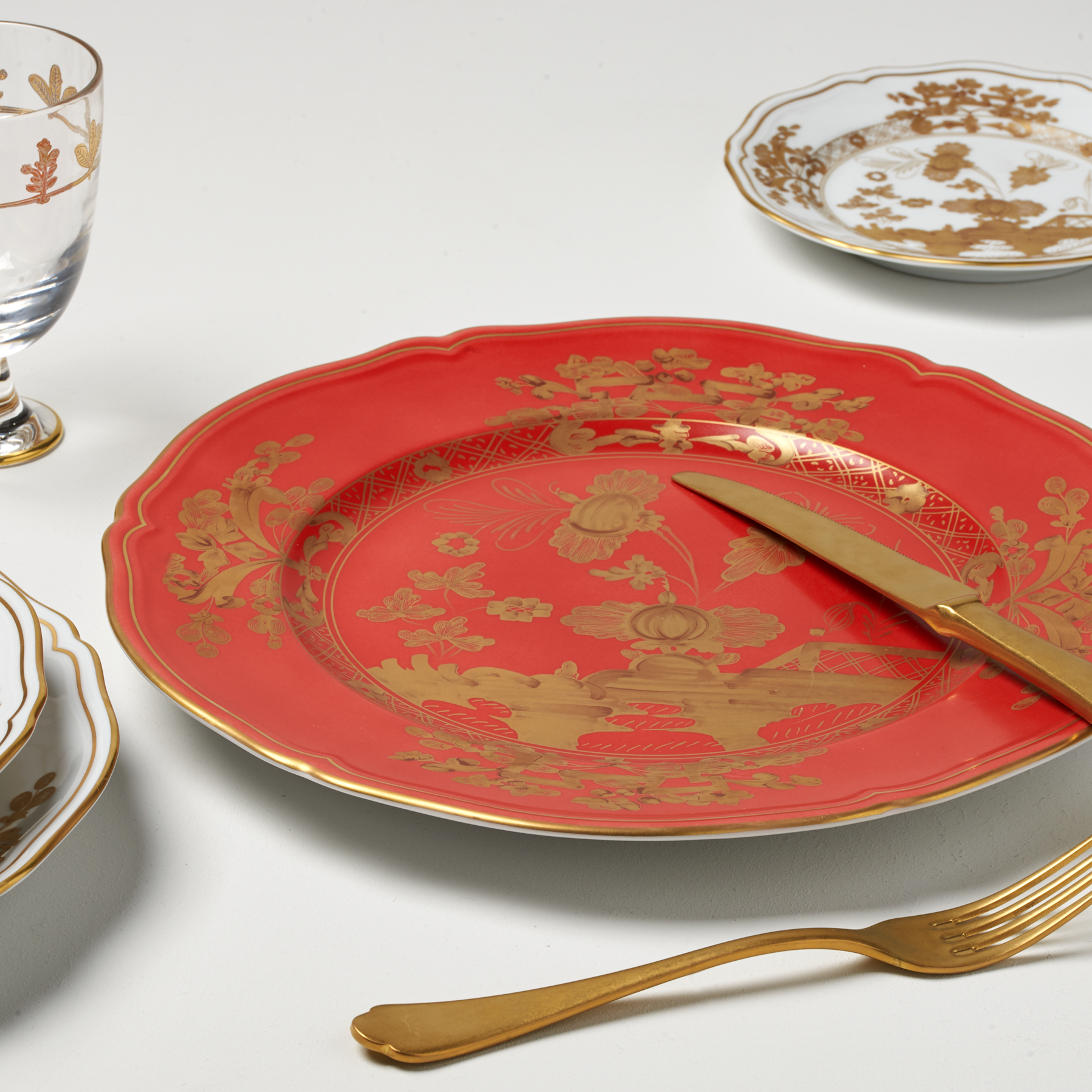 Elevate your dining experience with the exquisite Oriente Italiano Collection Porcelain RUBRUM Charger Plate, a masterpiece from Ginori 1735. This luxurious charger plate is meticulously crafted from fine white porcelain, offering a canvas for intricate artistry. The delicate floral ornamentation, hand-painted in pure gold, traces the classic lines of the Antico Doccia pattern, a signature of the esteemed Florentine Maison.