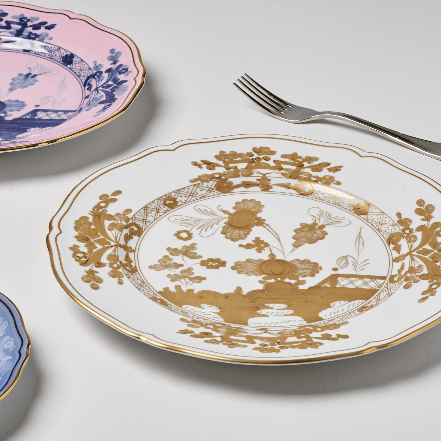 Elevate your dining experience with the exquisite Oriente Italiano Collection Porcelain AURUM Charger Plate, a masterpiece from Ginori 1735. This luxurious charger plate is meticulously crafted from fine white porcelain, offering a canvas for intricate artistry. The delicate floral ornamentation, hand-painted in pure gold, traces the classic lines of the Antico Doccia pattern, a signature of the esteemed Florentine Maison.