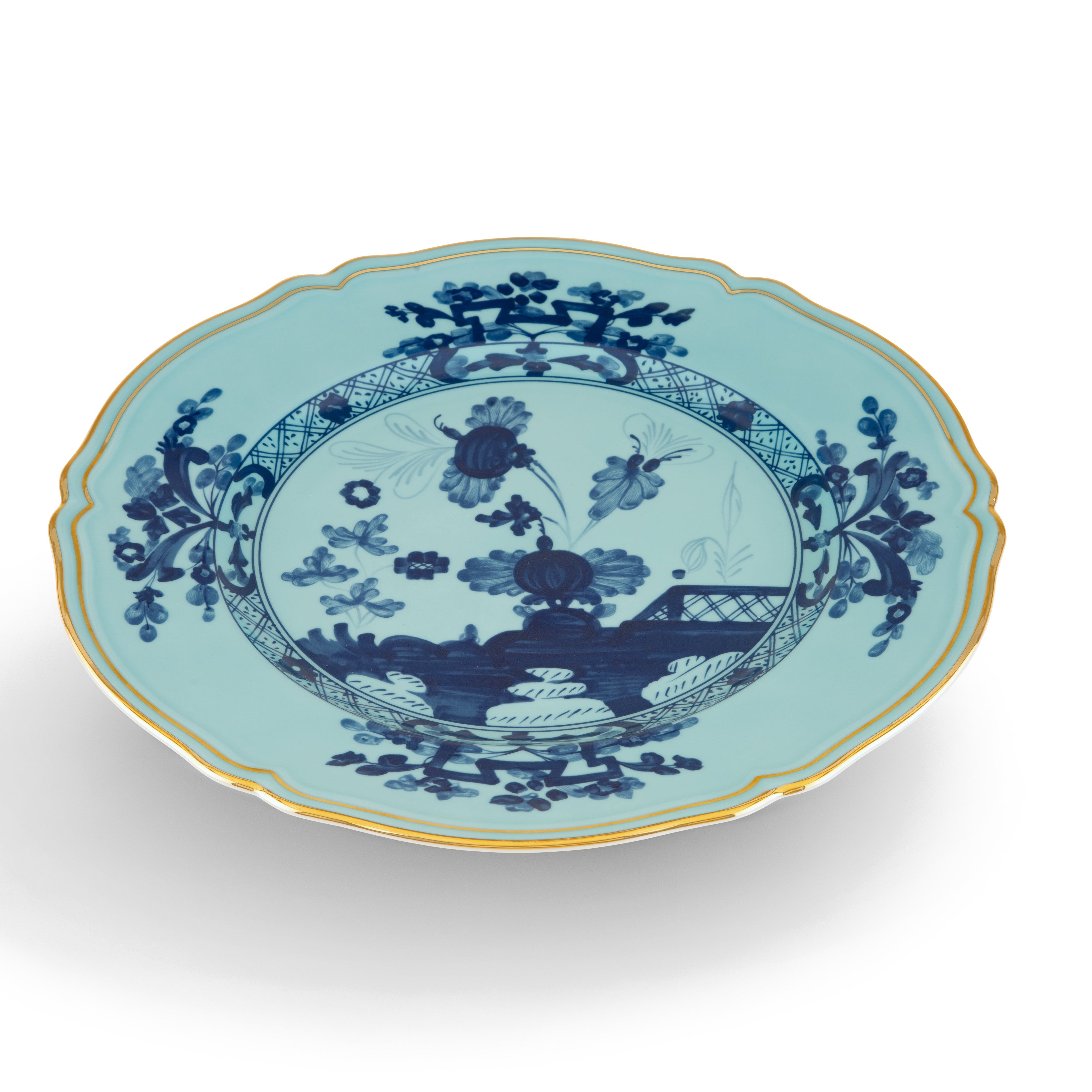 Elevate your dining experience with the exquisite Oriente Italiano Collection Porcelain Charger Plate, a masterpiece from Ginori 1735. This luxurious charger plate is meticulously crafted from fine white porcelain, offering a canvas for intricate artistry. The delicate floral ornamentation, hand-painted in pure gold, traces the classic lines of the Antico Doccia pattern, a signature of the esteemed Florentine Maison.