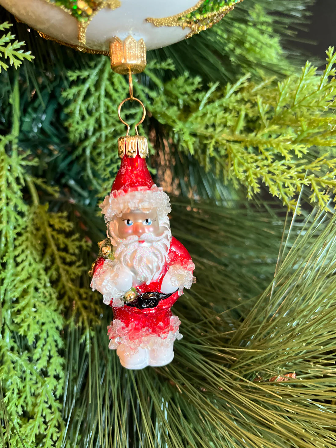 This exquisite ornament features Santa dropping from a gorgeous ball decorated with holly and gold leaves encrusted with chunky glitter and rhinestones.