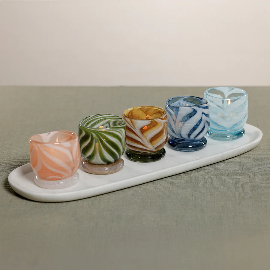 Bring warmth and artistry to your home with the Venezia Colored Tealight / Votive Holder by Zodax. Expertly crafted from 100% soda lime glass, this elegant candle holder features rich, swirling colors that beautifully diffuse candlelight, creating a soft, inviting glow
