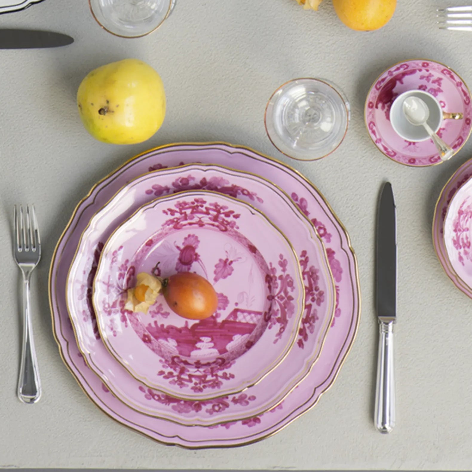 Porcelain Round Flat Platter from Oriente Italiano collection.Finished in a richer, partisan color palette of pink and red, the Porpora collection seemingly takes place at sunset with a warm garden scene of the Florentine “garofano” garden flower.