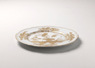 Elevate your dining experience with the exquisite Oriente Italiano Collection Porcelain  AURUM Charger Plate, a masterpiece from Ginori 1735. This luxurious charger plate is meticulously crafted from fine white porcelain, offering a canvas for intricate artistry. The delicate floral ornamentation, hand-painted in pure gold, traces the classic lines of the Antico Doccia pattern, a signature of the esteemed Florentine Maison.