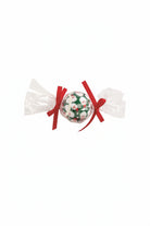 Three Christmas-themed tennis balls in clear wrappers with red, green, and floral designs on a white background.