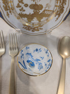 Set of gold and blue ceramic soy cup on a textured surface