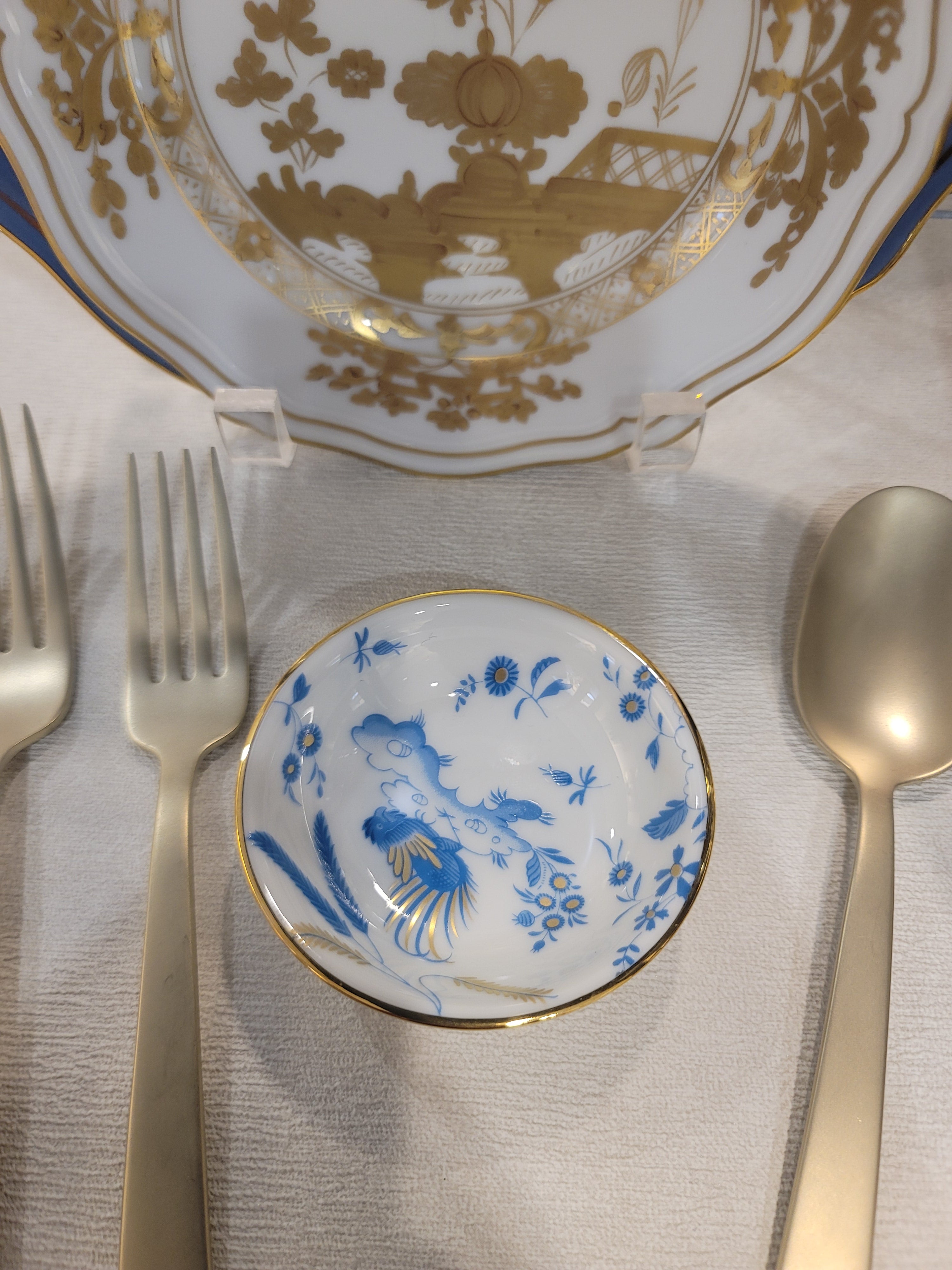 Set of gold and blue ceramic soy cup on a textured surface