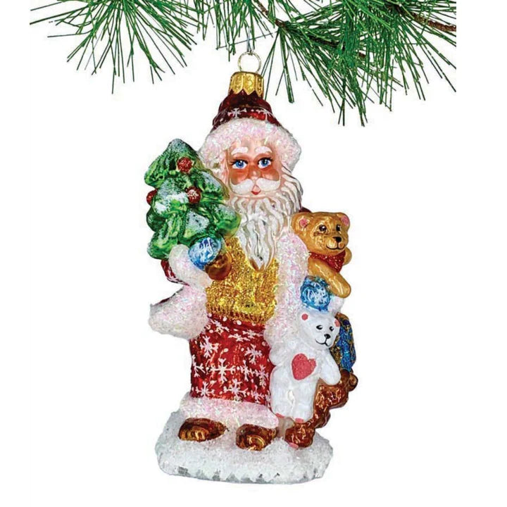 Heritage Santa Is A 6 Inch Handmade, Dimensional Glass Ornament Of Traditional Santa In Red With Glittered Snowflakes Carrying A Green Christmas And A Trio Of Teddy Bears.