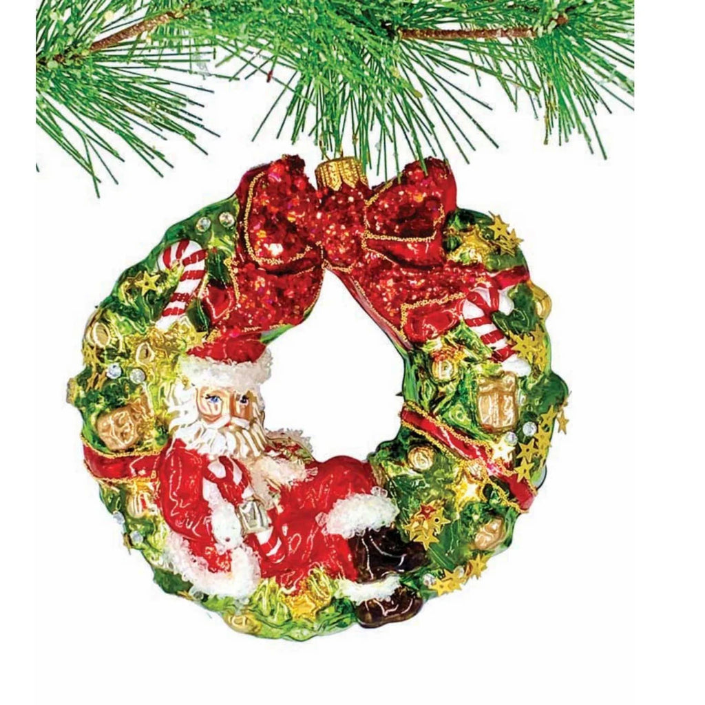 Long Winters Nap Ornament Is A Figural Santa Christmas Ornament Made Of Glass. This 5 Inch Figural Ornament Captures Santa Comfortably Napping On A Decked Out Wreath.